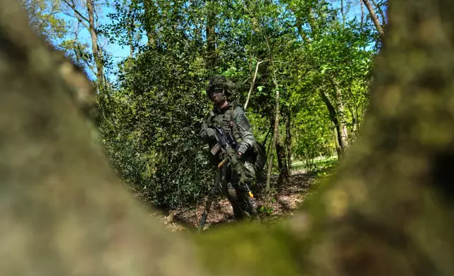 A member of the 10th Infantry Battalion Guard Security Corps National Reserve searches for enemy positions during a weekend exercise meant to hone military skills as the Netherlands beefs up its military with new recruits and volunteer reservists in Havelte, Netherlands, Saturday, April 25, 2026. (AP Photo/Peter Dejong)