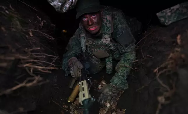 A member of the 10th Infantry Battalion Guard Security Corps National Reserve crawls out of a foxhole during a weekend exercise as the Netherlands beefs up its military with new recruits and volunteer reservists in Havelte, Netherlands, Saturday, April 25, 2026. (AP Photo/Peter Dejong)