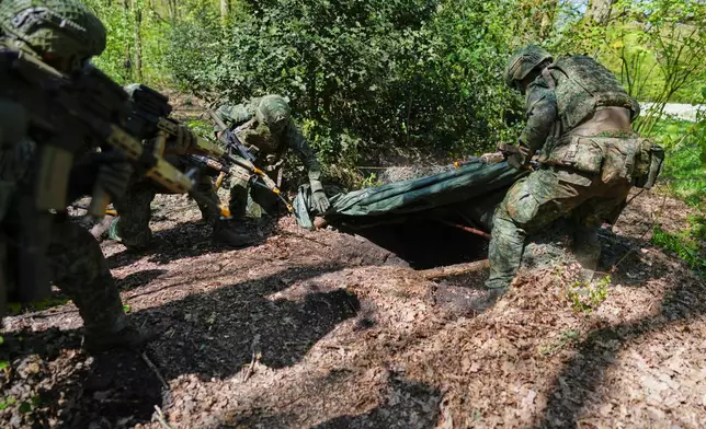 Members of the 10th Infantry Battalion Guard Security Corps National Reserve unearth an enemy foxhole during a weekend exercise to hone their military skills as the Netherlands beefs up its military with new recruits and volunteer reservists in Havelte, Netherlands, Saturday, April 25, 2026. (AP Photo/Peter Dejong)