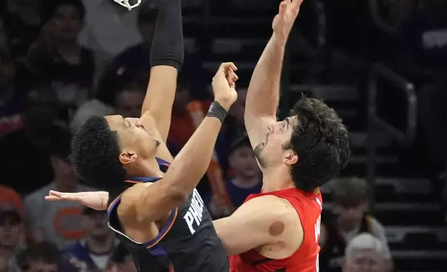 Portland Trail Blazers forward Deni Avdija, right, scores against Phoenix Suns forward Ryan Dunn, left, during the second half of an NBA play-in tournament basketball game, Tuesday, April 14, 2026, in Phoenix. (AP Photo/Ross D. Franklin)
