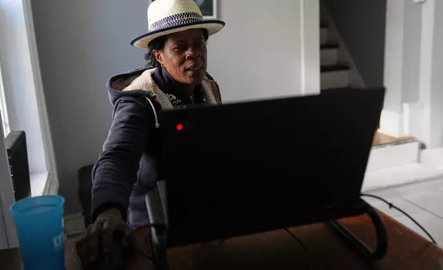 Jevona Anderson, a student at the University of Baltimore, reviews online assignments in her home Tuesday, April 7, 2026, in Baltimore. (AP Photo/Stephanie Scarbrough)