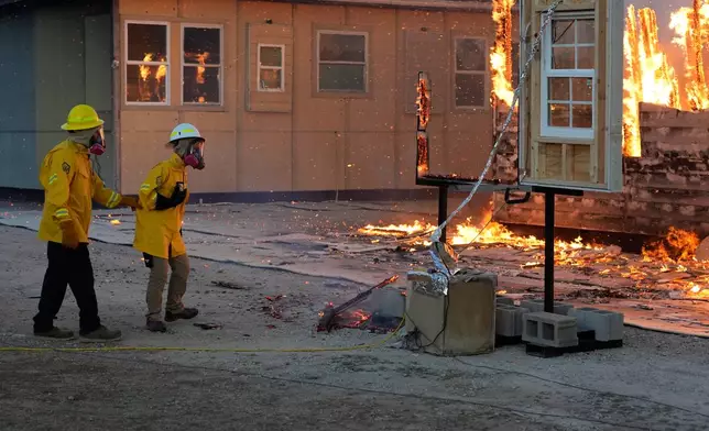 Wildfire researchers watch an accessory dwelling unit burn during an experiment at the Institute for Business &amp; Home Safety center on Thursday, April 16, 2026, in Richburg, S.C. (AP Photo/Erik Verduzco)