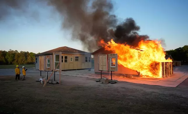 Wildfire researchers watch an accessory dwelling unit burn during an experiment at the Institute for Business &amp; Home Safety center on Thursday, April 16, 2026, in Richburg, S.C. (AP Photo/Erik Verduzco)