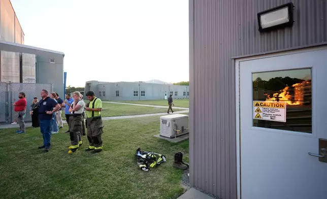 Wildfire researchers and firefighters watch as an accessory dwelling unit burns during an experiment at the Institute for Business &amp; Home Safety center on Thursday, April 16, 2026, in Richburg, S.C. (AP Photo/Erik Verduzco)