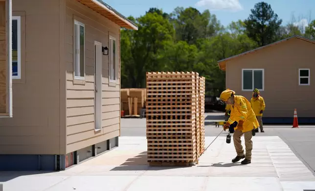 Lead carpenter David Trull ignites wood cribs for an accessory dwelling unit burn experiment at the Institute for Business &amp; Home Safety center Wednesday, April 1, 2026, in Richburg, S.C. (AP Photo/Erik Verduzco)