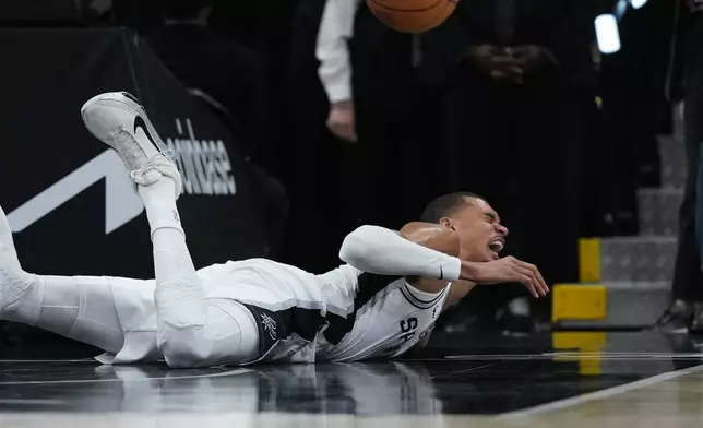 San Antonio Spurs forward Victor Wembanyama (1) takes a hard fall on the court during the first half in Game 2 of a first-round NBA playoffs basketball series against the Portland Trail Blazers in San Antonio, Tuesday, April 21, 2026. (AP Photo/Eric Gay)