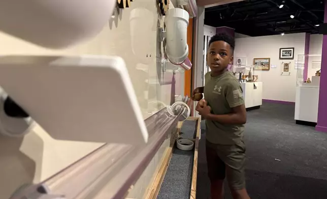 Jackson Strong, 9, plays with an interactive section of the Mississippi Made exhibit on Friday, March 27, 2026, in Jackson, Miss. (AP Photo/Sophie Bates)