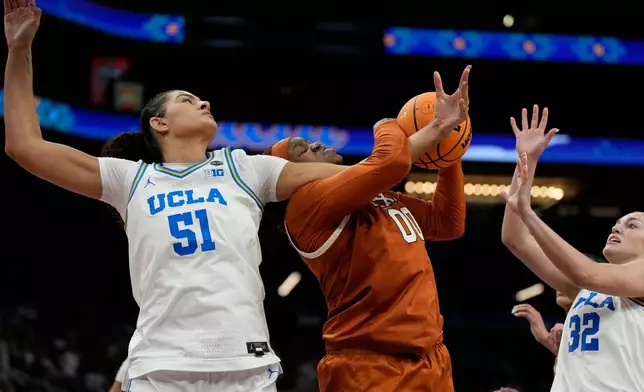 UCLA center Lauren Betts (51) and Texas center Kyla Oldacre (00) battle for the ball during the second half of a women's NCAA college basketball tournament semifinal game at the Final Four, Friday, April 3, 2026, in Phoenix. (AP Photo/Ross D. Franklin)