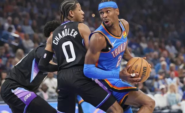 Oklahoma City Thunder guard Shai Gilgeous-Alexander (2) looks to go to the basket against Utah Jazz guard Kennedy Chandler (0) during the first half of an NBA basketball game Sunday, April 5, 2026, in Oklahoma City. (AP Photo/Nate Billings)