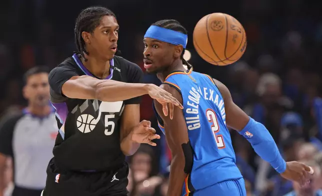 Utah Jazz forward Cody Williams (5) passes the ball away from Oklahoma City Thunder guard Shai Gilgeous-Alexander (2) during the first half of an NBA basketball game Sunday, April 5, 2026, in Oklahoma City. (AP Photo/Nate Billings)