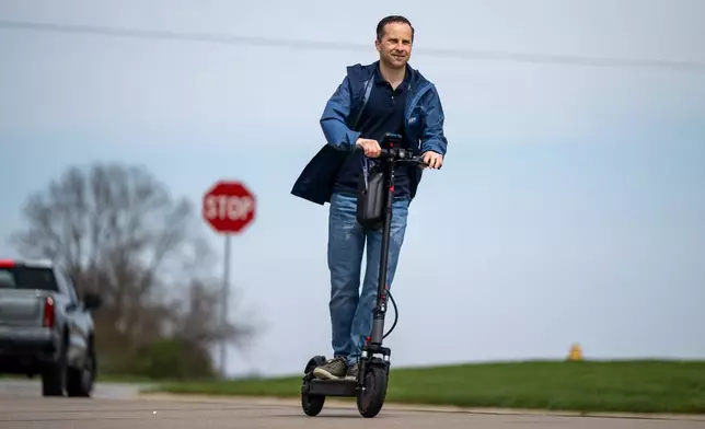 Indiana state Sen. Spencer Deery, R-West Lafayette, who represents District 23, canvasses a neighborhood on an electric scooter, Saturday, April 11, 2026, in West Lafayette, Ind. (AP Photo/Doug McSchooler)