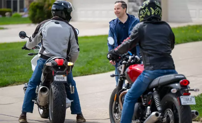Indiana state Sen. Spencer Deery, R-West Lafayette, who represents District 23, is stopped by passersby while canvassing a neighborhood, Saturday, April 11, 2026, in West Lafayette, Ind. (AP Photo/Doug McSchooler)
