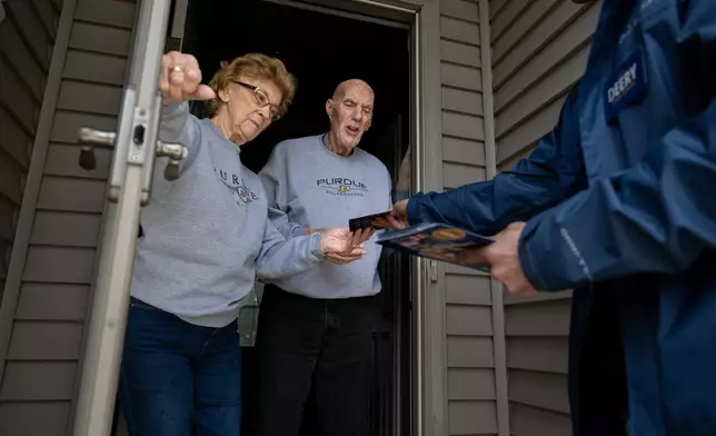 Retired couple Annette Williams, and her husband, Curtis Williams, speak with Indiana state Sen. Spencer Deery, R-West Lafayette, who represents District 23, after he stops at their home while canvassing a neighborhood, Saturday, April 11, 2026, in West Lafayette, Ind. (AP Photo/Doug McSchooler)