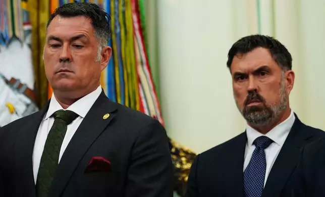 Marcus Luttrell, a retired U.S. Navy Seal, and his brother, Rep. Morgan Luttrell, R-Texas, listen to President Donald Trump speak in the Oval Office of the White House, Saturday, April 18, 2026, in Washington. (AP Photo/Julia Demaree Nikhinson)