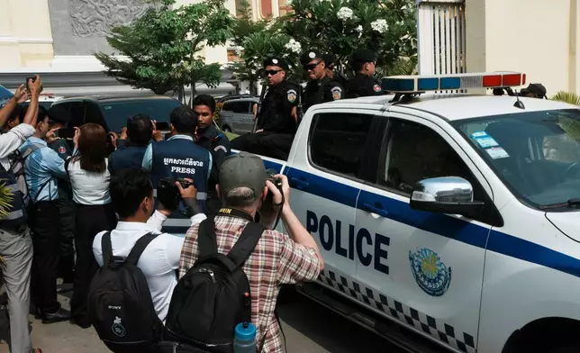 Journalists try to photograph as a vehicle which is believed to carry former Cambodia National Rescue Party's President Kem Sokha heads out from an appeals court after the court session in Phnom Penh, Cambodia, Thursday, April 30, 2026. (AP Photo/Heng Sinith)