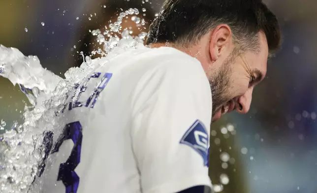 Los Angeles Dodgers' Kyle Tucker is showered with water during an interview after hitting a walk off single during the ninth inning of a baseball game against the Miami Marlins Monday, April 27, 2026, in Los Angeles. (AP Photo/Ryan Sun)