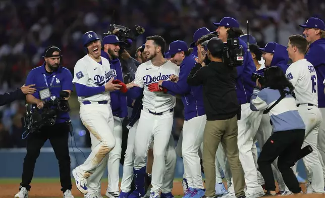 Los Angeles Dodgers' Kyle Tucker, center, celebrates with teammates after hitting a walk off single during the ninth inning of a baseball game against the Miami Marlins Monday, April 27, 2026, in Los Angeles. (AP Photo/Ryan Sun)