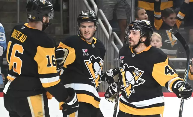 Pittsburgh Penguins defenseman Ryan Shea (5) celebratesa goal with right wing Justin Brazeau (16) and defenseman Samuel Girard (49) against the Florida Panthers during the second period of an NHL game, Saturday, April 4, 2026, in Pittsburgh. (AP Photo/Philip G. Pavely)