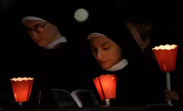 Faithful attend the Via Crucis, the torchlit Good Friday Stations of the Cross procession led by Pope Leo XIV at the Colosseum in Rome, Friday, April 3, 2026, which symbolically retraces Jesus Christ's steps to his crucifixion on Calvary in Jerusalem. (AP Photo/Gregorio Borgia)