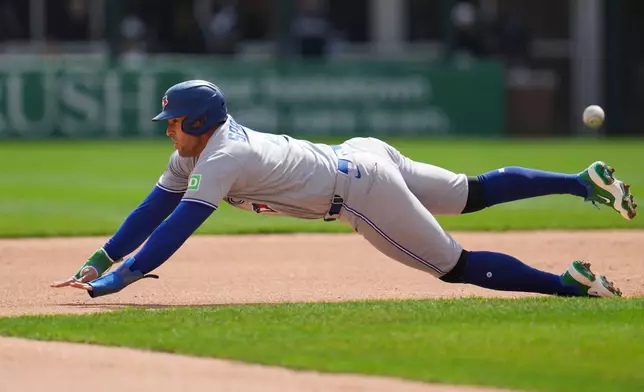 Toronto Blue Jays' George Springer (4) steals second base during the third inning of a home-opener baseball game against the Chicago White Sox, Friday, April 3, 2026, in Chicago. (AP Photo/Erin Hooley)