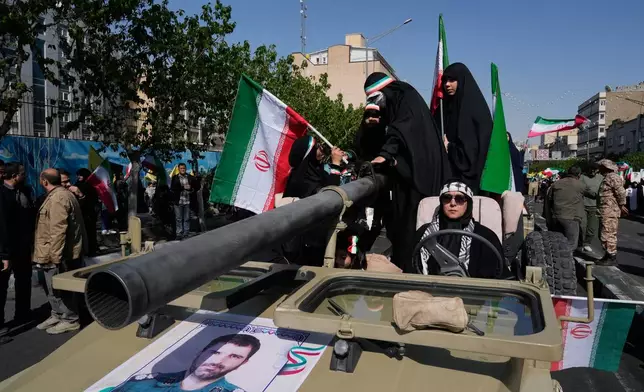 Women members of the Basij paramilitary, affiliated with Iran's Revolutionary Guard, march with their weapons during a state-organized rally in support of the supreme leader marking National Girl's Day in Tehran, Iran, Friday, April 17, 2026. (AP Photo/Vahid Salemi)