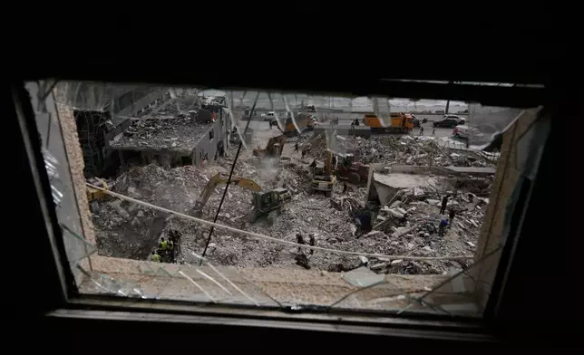 Excavators remove rubble from destroyed buildings that were hit on Thursday by Israeli airstrikes, as they keep searching for victims in Tyre city, southern Lebanon, Saturday, April 18, 2026. (AP Photo/Bilal Hussein)