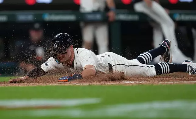 Detroit Tigers' Kevin McGonigle slides safely into home plate against the Kansas City Royals during the eighth inning of a baseball game Tuesday, April 14, 2026, in Detroit. (AP Photo/Paul Sancya)