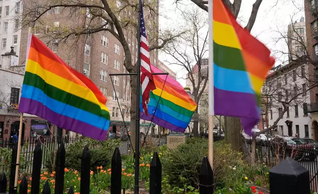 Small rainbow Pride flags are displayed near a flagpole with a larger Pride flag at the Stonewall National Monument in New York, Monday, April 13, 2026. (AP Photo/Seth Wenig)
