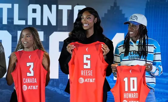 Atlanta Dream's Jordin Canada, Angel Reese And Rhyne Howard hold up their jerseys during a news conference by the Atlanta Dream on Friday, April 17, 2026, in Atlanta. (AP Photo/Brynn Anderson)