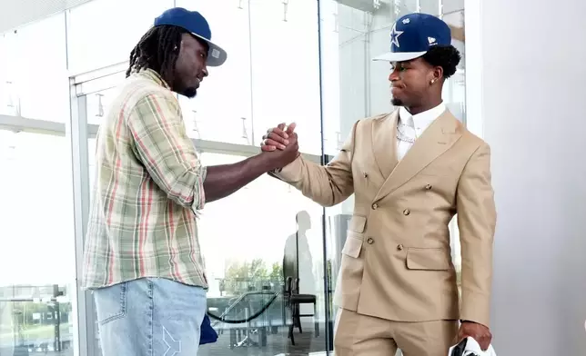 Dallas Cowboys first-round draft picks Malachi Lawrence, left, and Caleb Downs, right, greet each other after a news conference at the team's NFL football headquarters Friday, April 24, 2026, in Frisco, Texas. (AP Photo/Tony Gutierrez)