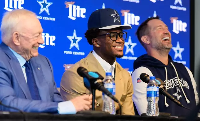 Dallas Cowboys team owner Jerry Jones, left and head coach Brian Schottenheimer, right, react as first round draft pick Caleb Downs, center, responds to a question during a news conference at the team's NFL football headquarters Friday, April 24, 2026, in Frisco, Texas. (AP Photo/Tony Gutierrez)