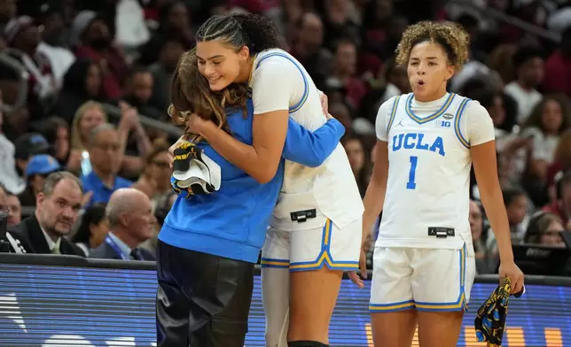 UCLA head coach Cori Close, left, hugs UCLA center Lauren Betts (51) during the second half of the women's National Championship Final Four NCAA college basketball tournament game against South Carolina, Sunday, April 5, 2026, in Phoenix. (AP Photo/Rick Scuteri)