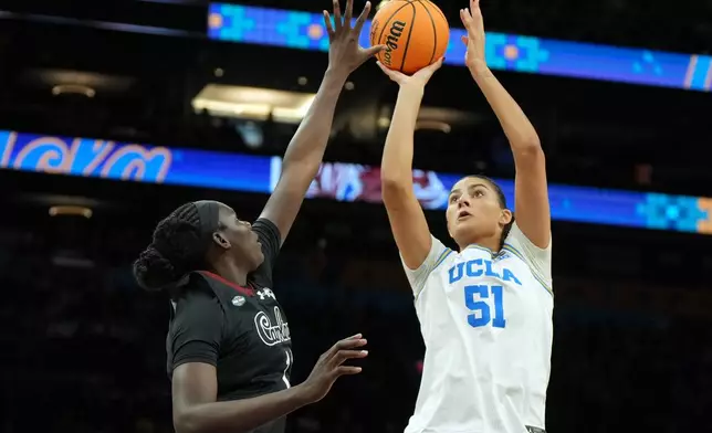 UCLA center Lauren Betts (51) shoots over South Carolina center Madina Okot (11) during the second half of the women's National Championship Final Four NCAA college basketball tournament game, Sunday, April 5, 2026, in Phoenix. (AP Photo/Rick Scuteri)