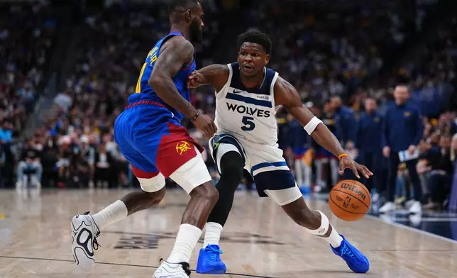 Minnesota Timberwolves guard Anthony Edwards (5) drives to the basket against Denver Nuggets guard Tim Hardaway Jr. (10) during the second half in Game 2 of a first-round NBA playoffs basketball series Monday, April 20, 2026, in Denver. (AP Photo/Jack Dempsey)