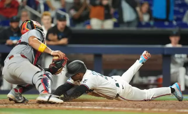 St. Louis Cardinals catcher Ivan Herrera tags out Miami Marlins' Xavier Edwards as he slides home on a single by Liam Hicks, during the sixth inning of a baseball game, Monday, April 20, 2026, in Miami. (AP Photo/Rebecca Blackwell)