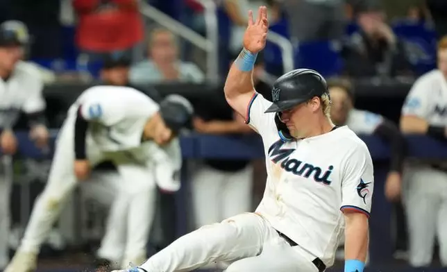 Miami Marlins' Kyle Stowers slides home to score on a double by Otto Lopez during the sixth inning of a baseball game against the St. Louis Cardinals, Monday, April 20, 2026, in Miami. (AP Photo/Rebecca Blackwell)