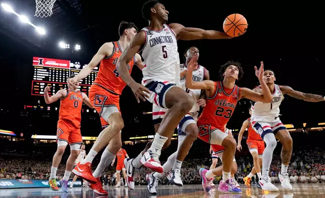 UConn forward Tarris Reed Jr. (5) rebounds as Illinois guard Keaton Wagler (23) pursues during the first half of an NCAA college basketball tournament semifinal game at the Final Four, Saturday, April 4, 2026, in Indianapolis. (AP Photo/Abbie Parr)