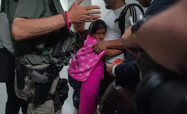 FILE - An asylum seeker from Ecuador hugs her father as he is detained by federal agents July 31, 2025 (AP Photo/Olga Fedorova, File)