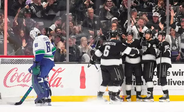 Los Angeles Kings right wing Joel Armia, second from left, celebrates his goal with teammates as Vancouver Canucks goaltender Nikita Tolopilo stands in goal during the first period of an NHL hockey game Thursday, April 9, 2026, in Los Angeles. (AP Photo/Mark J. Terrill)
