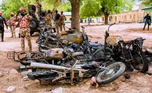 In this photo, released by Adamawa State Government House, a soldier takes photos of burned motorbikes in Guyaku, northeastern Nigeria, Monday, April 27, 2026, following an attack by Militants with the Islamic State group on Sunday. (Adamawa state government house via AP)