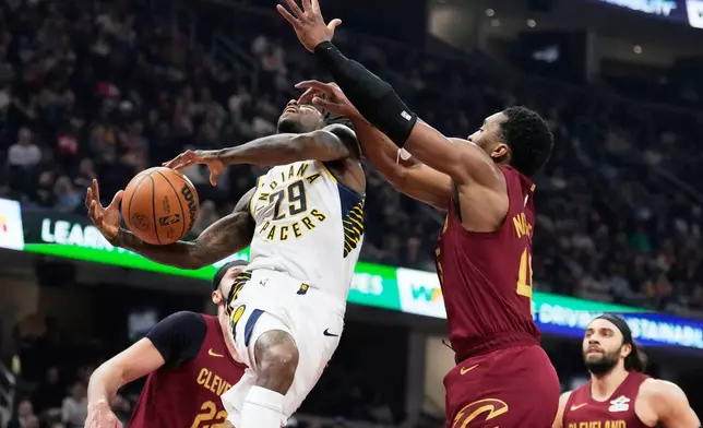 Indiana Pacers guard Quenton Jackson (29) is fouled by Cleveland Cavaliers guard Donovan Mitchell, right, in the first half of an NBA basketball game in Cleveland, Sunday, April 5, 2026. (AP Photo/Sue Ogrocki)