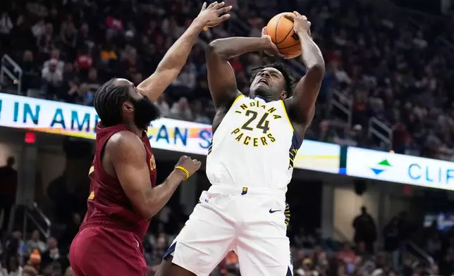 Indiana Pacers guard Kobe Brown (24) shoots as Cleveland Cavaliers guard James Harden, left, defends in the first half of an NBA basketball game in Cleveland, Sunday, April 5, 2026. (AP Photo/Sue Ogrocki)