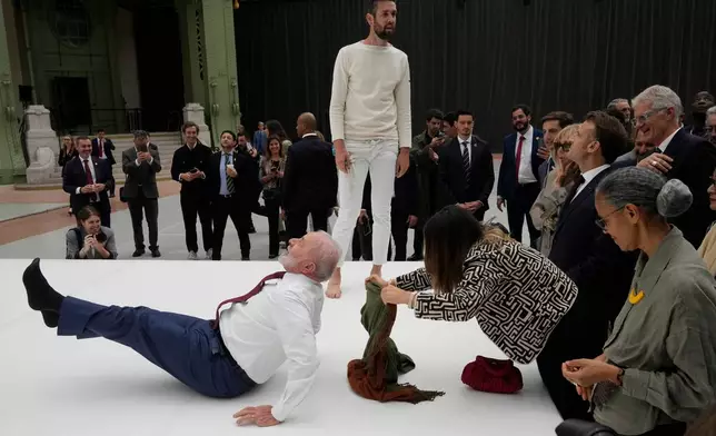 FILE - Brazil's President Luiz Inacio Lula da Silva spontaneously shows off an acrobatic pose inspired by the Ernesto Neto exhibition, during his visit to the Grand Palais museum in Paris, June 6, 2025. (AP Photo/Michel Euler, File)