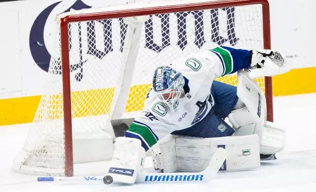 Vancouver Canucks goaltender Kevin Lankinen (32) blocks a shot during the first period of an NHL hockey game against the San Jose Sharks in San Jose, Calif., Saturday, April 11, 2026. (Stephen Lam/San Francisco Chronicle via AP)