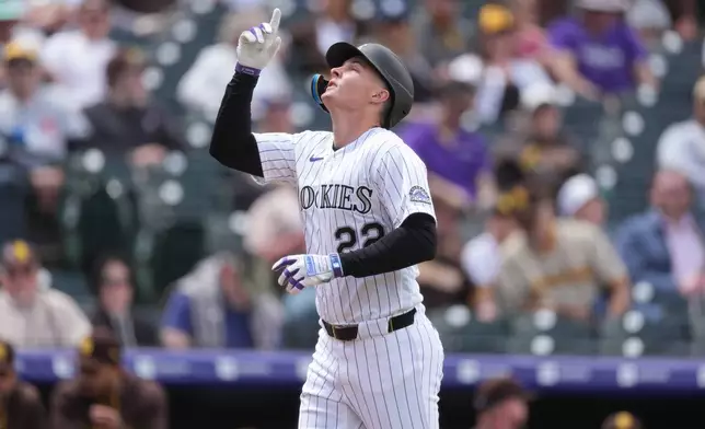 Colorado Rockies' Mickey Moniak gestures as he crosses home plate after hitting a solo home run off San Diego Padres starting pitcher Matt Waldron in the first inning of a baseball game Thursday, April 23, 2026, in Denver. (AP Photo/David Zalubowski)