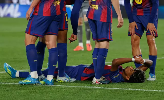 Barcelona's Lamine Yamal lies on the pitch in pain during the Spanish La Liga soccer match between Barcelona and Celta Vigo in Barcelona, Spain, Wednesday, April 22, 2026. (AP Photo/Joan Monfort)