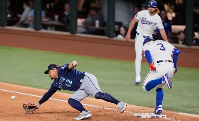 Texas Rangers' Joc Pederson (3) reaches on a single as Seattle Mariners first baseman Josh Naylor (12) dives for an errant throw to the bag in the fifth inning of a baseball game Tuesday, April 7, 2026, in Arlington, Texas. (AP Photo/Tony Gutierrez)