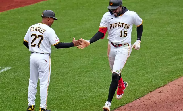 Pittsburgh Pirates' Oneil Cruz (15) is greeted by third base coach Tony Beasley as he rounds third base after hitting a two-run home run off Baltimore Orioles pitcher Cade Povich during the sixth inning of a baseball game in Pittsburgh, Sunday, April 5, 2026. (AP Photo/Gene J. Puskar)