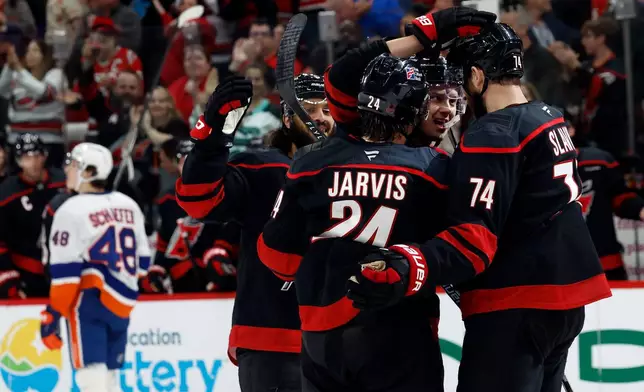 Carolina Hurricanes' Sebastian Aho, second right, celebrates his goal with teammates Jaccob Slavin, right, Seth Jarvis (24) and Jalen Chatfield, left, during the second period of an NHL hockey game against the New York Islanders in Raleigh, N.C., Saturday, April 4, 2026. (AP Photo/Karl DeBlaker)