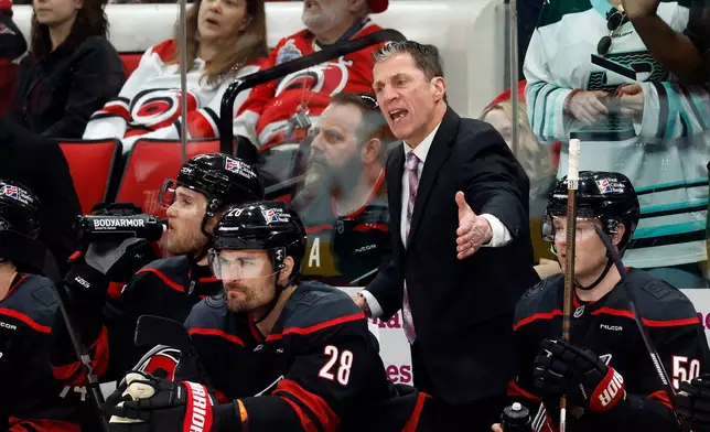 Carolina Hurricanes' Rod Brind'Amour, center, protests a call with officials during the second period of an NHL hockey game against the New York Islanders in Raleigh, N.C., Saturday, April 4, 2026. (AP Photo/Karl DeBlaker)
